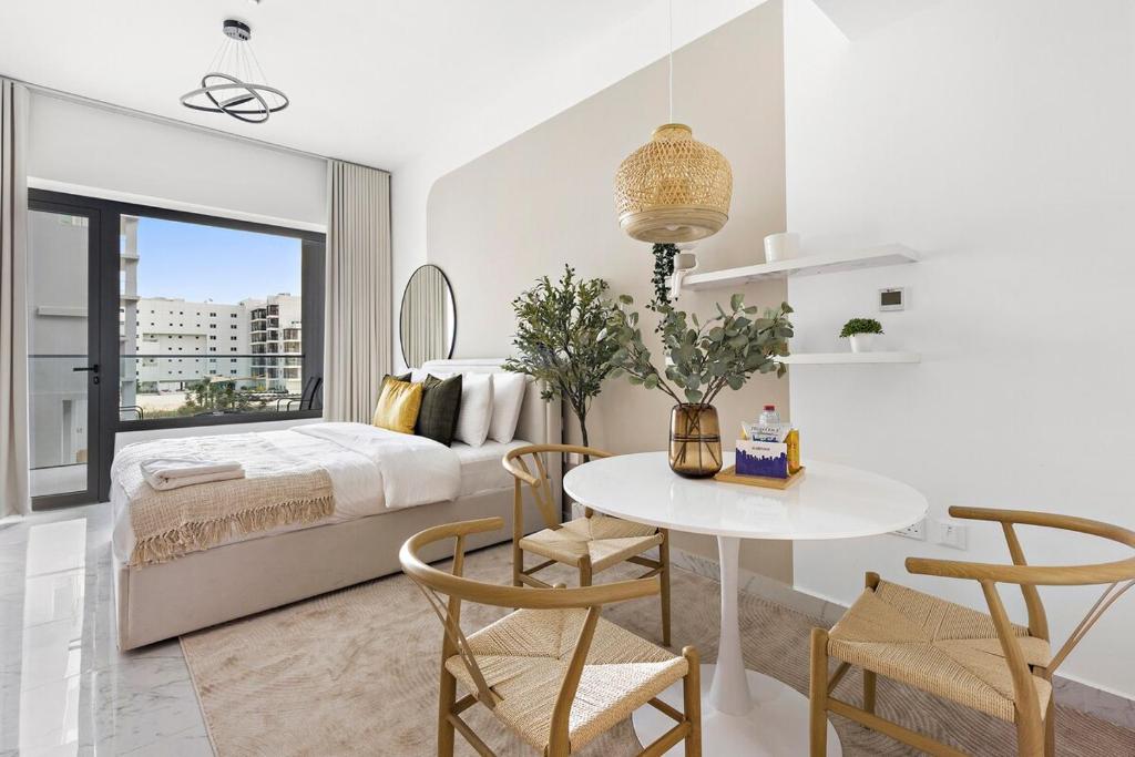 a bedroom with a bed and a table and chairs at Bright Boho Loft near Yas F1 Circuit & Airport in Abu Dhabi
