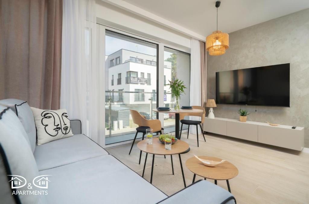 Una sala de estar con un sofá y un televisor. en Milano 12 D&D Apartments, en Międzywodzie