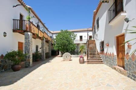 a courtyard of a building with a staircase and buildings at Molino Cuatro Paradas in Benaoján