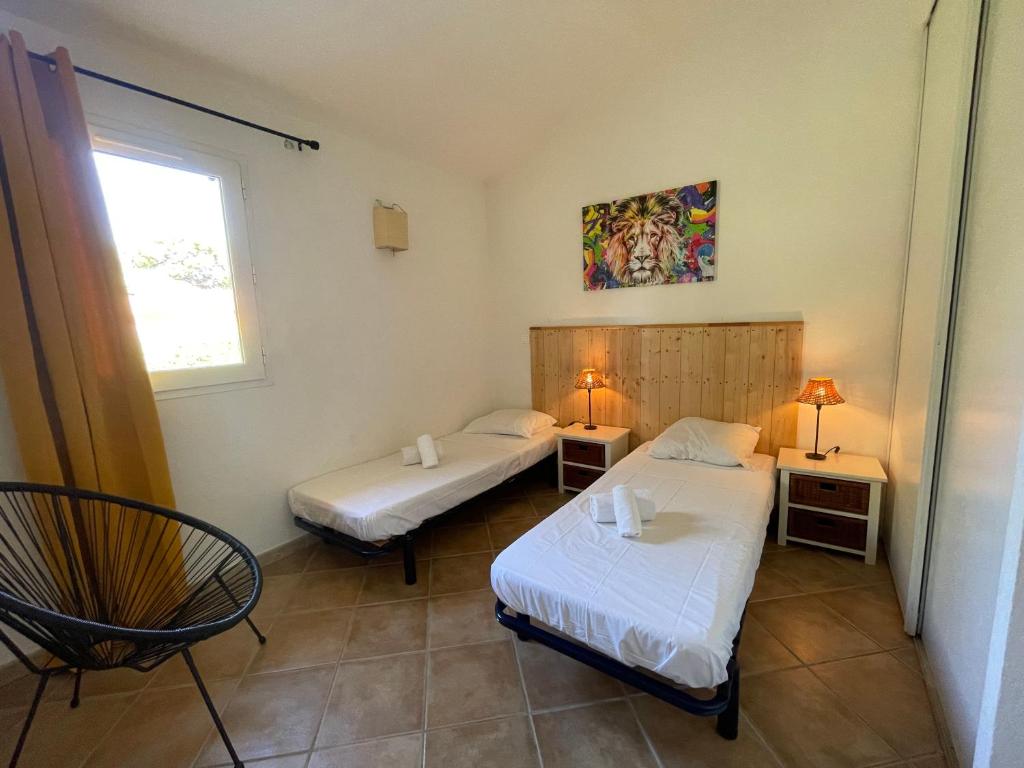 een kamer met twee bedden en een raam bij Villa Immortelle, Piscine, SPA, 500m plages et commerces in Lecci