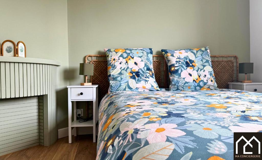 une chambre avec un lit avec une couette fleurie dans l'établissement Harmonie - Premium, Central, 2 chambres & Parking GRATUIT, à Boulogne-sur-Mer