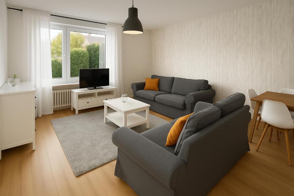 a living room with a couch and a tv at Köln Pulheim 63 in Pulheim