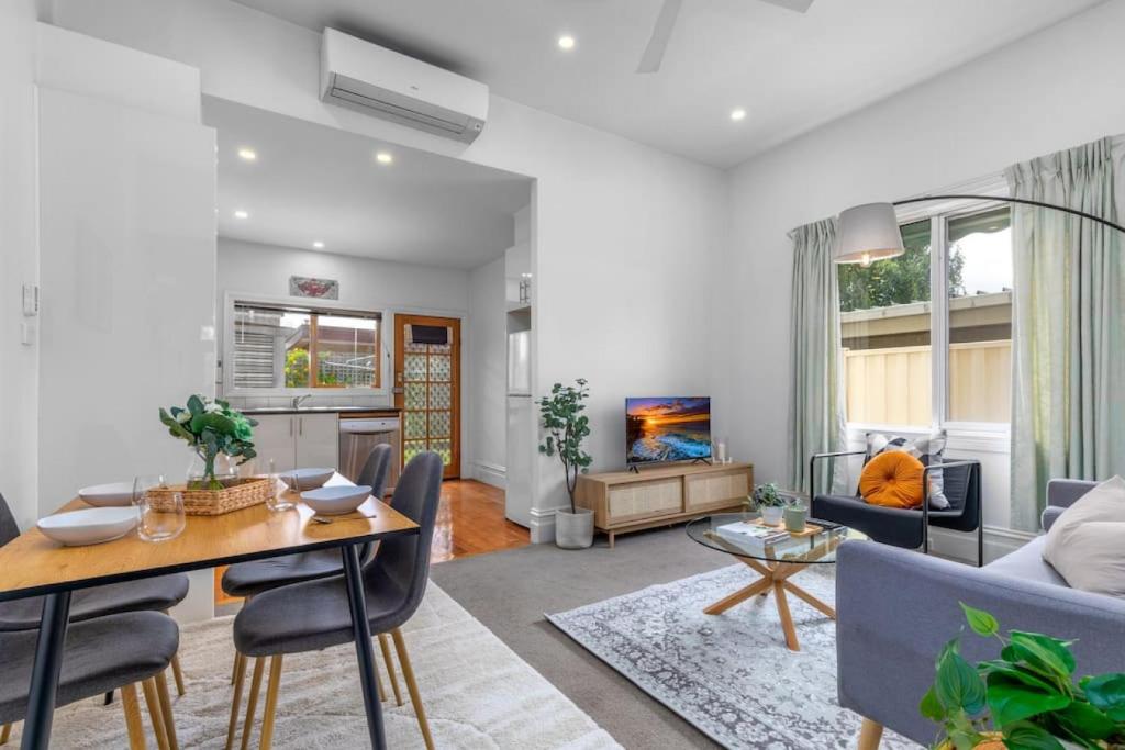 a living room with a table and chairs and a couch at Cosy 2 bedroom house in Melbourne
