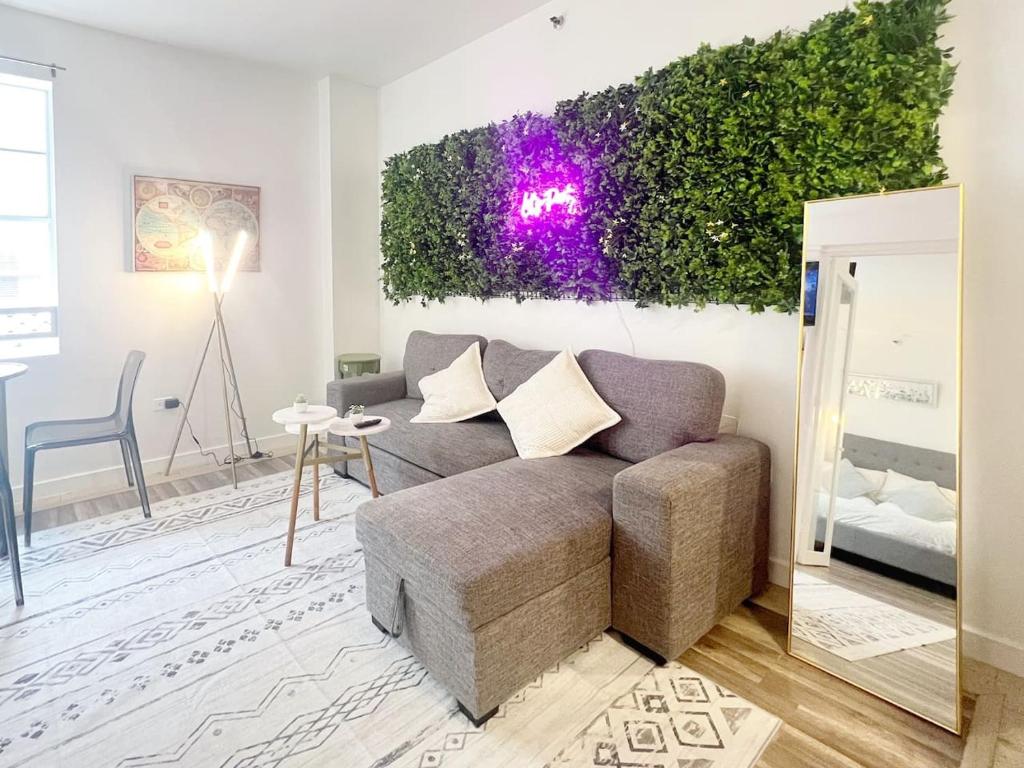 a living room with a couch and a plant on the wall at Pool and Jacuzzi. Walk to beach, South Point Pier in Miami Beach