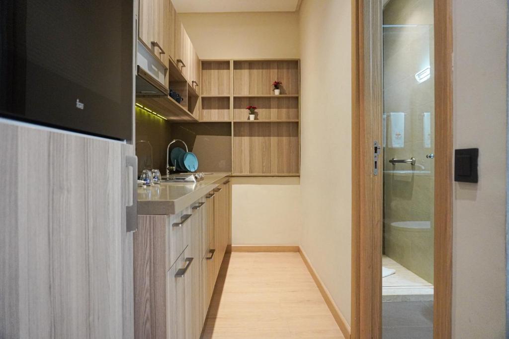 una piccola cucina con armadi in legno e lavandino di Flamant Rose Appart Hotel a Tangeri