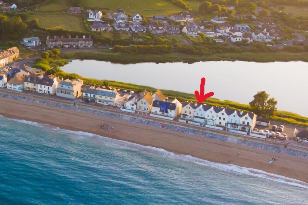 Luftaufnahme eines Strandes mit Häusern und dem Meer in der Unterkunft Goodwinds 4 bedroom beachside house in Torcross