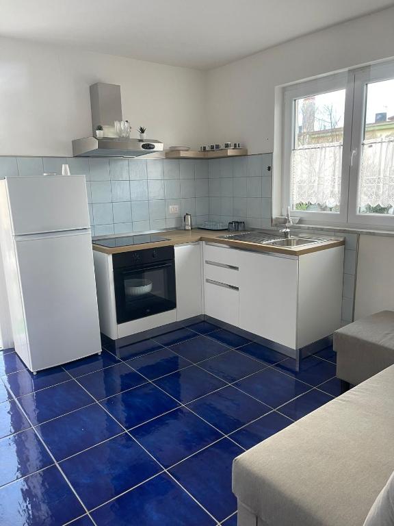 a kitchen with a blue tile floor and white appliances at MAGA House in Pontecagnano