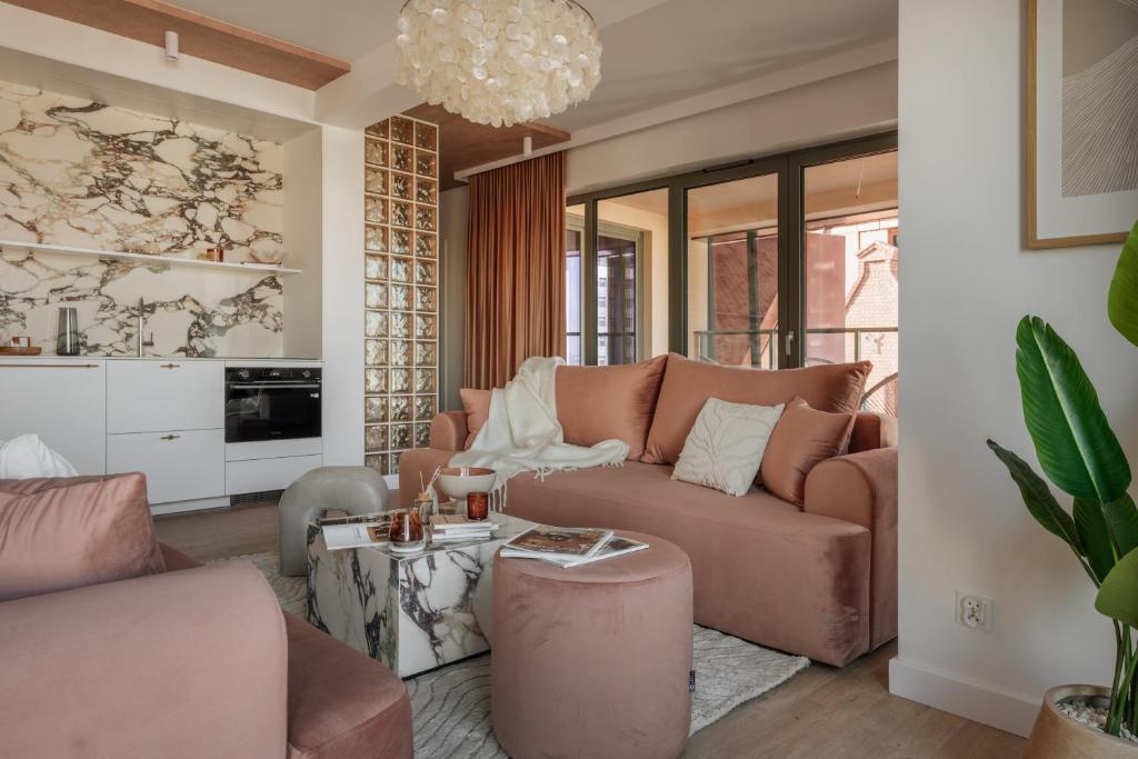 a living room with a couch and a table at Casa Blush - LoftAffair Spa Collection in Gdańsk