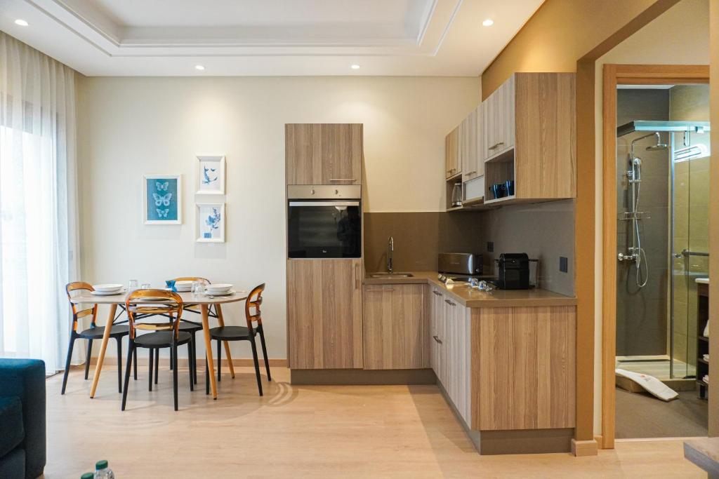 una cucina e una sala da pranzo con tavolo e sedie di Flamant Rose Appart Hotel a Tangeri