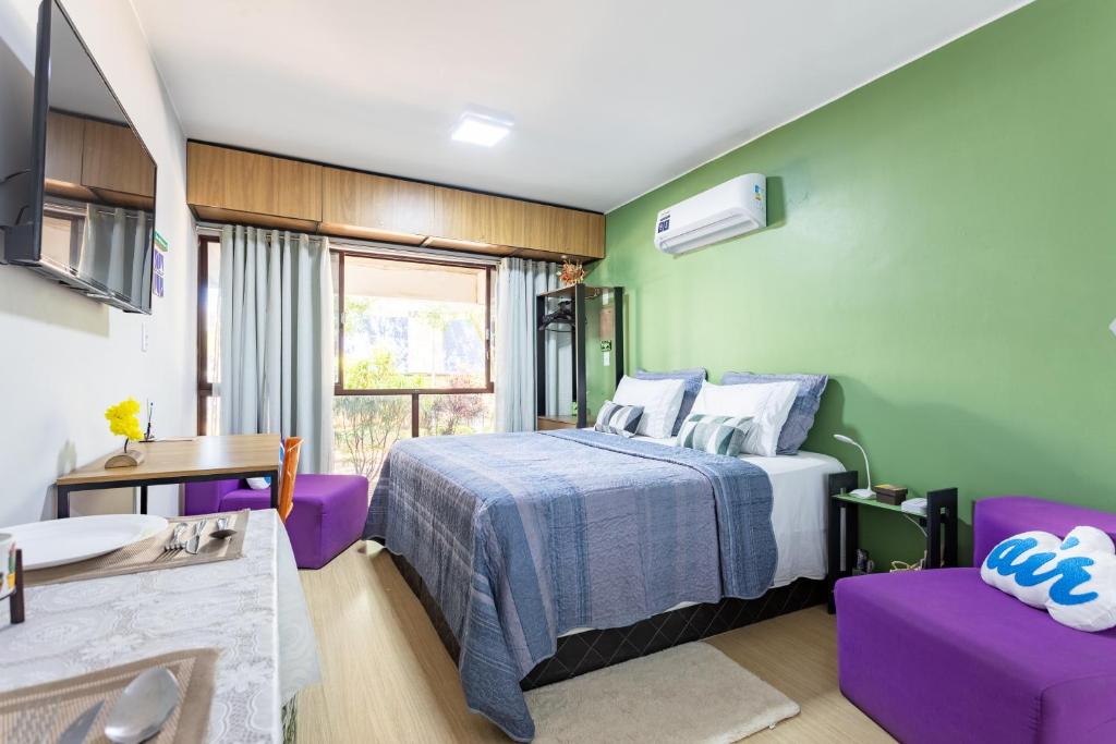 a bedroom with a bed with purple furniture and a sink at Estúdio aconchegante e funcional - cama casal ou 2 de solteiro - ar condicionado - wifi - netflix - cozinha in Brasilia