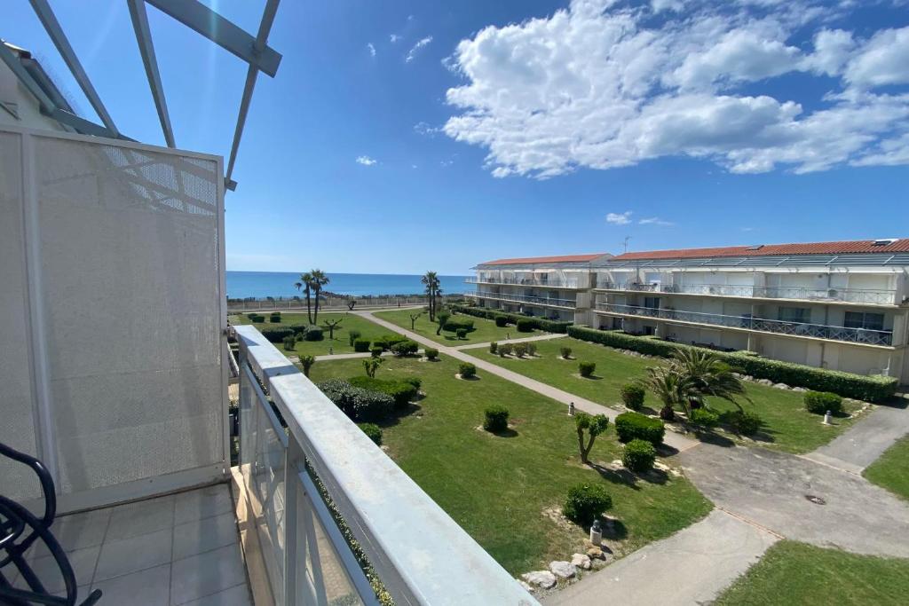 un balcon avec vue sur un immeuble et un parc dans l'établissement Between Sky and Waves, à Aresquies