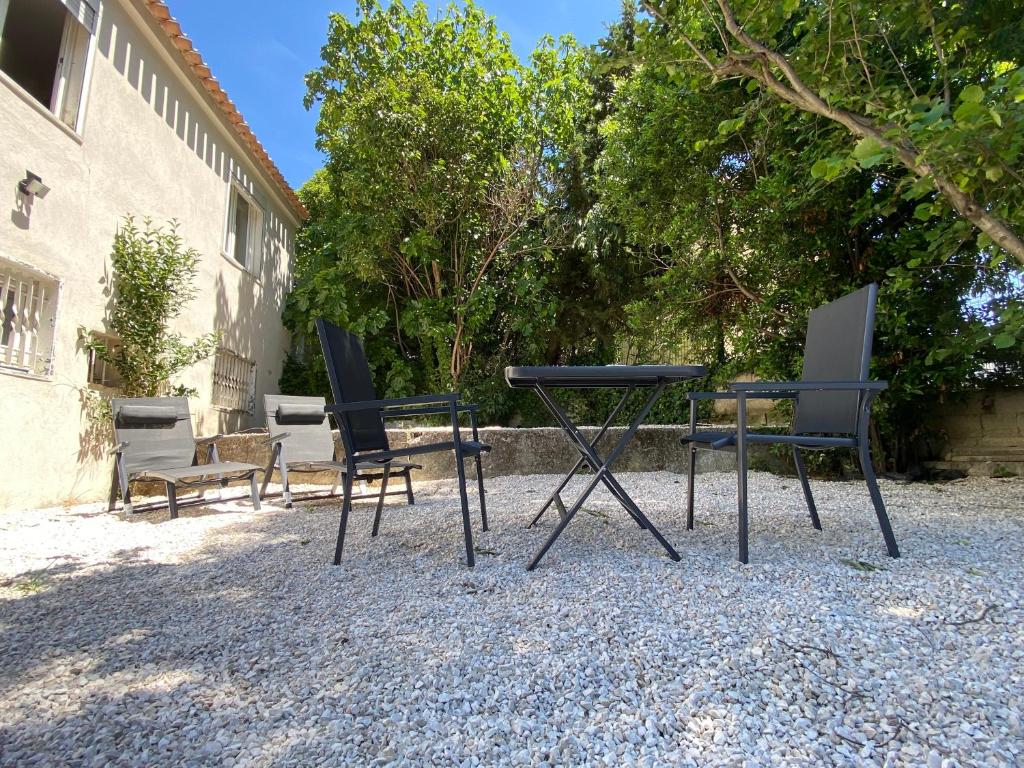 3 chaises et une table devant un bâtiment dans l'établissement Studio avec terrasse privative, à Marseille