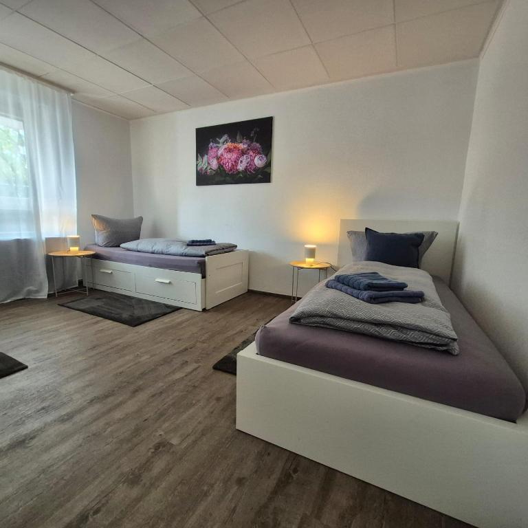a bedroom with two beds and a window at Budget Base Apartment - 3 x Einzelzimmer in Braunschweig