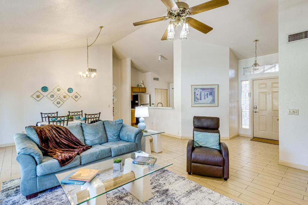 un soggiorno con divano blu e ventilatore a soffitto di Southwest Getaway with Fenced Yard in Chandler! a Chandler