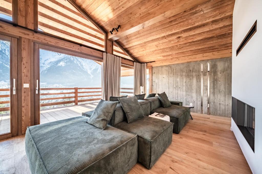 a living room with a large couch and a large window at Chalet Foxden in Les Houches