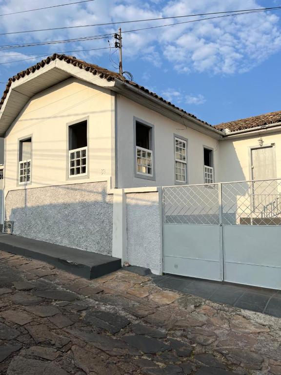 a white house with a fence in front of it at Casa 89 in Diamantina