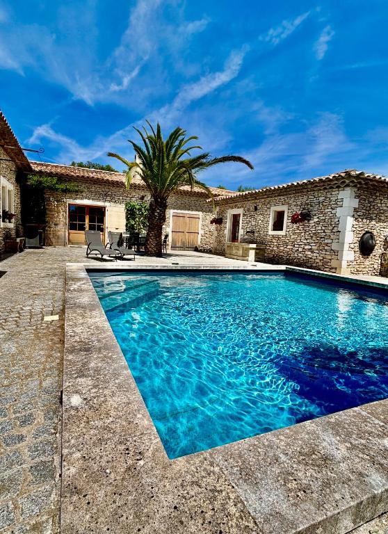 une piscine devant une maison dans l'établissement Maison en pierre, à Grignan