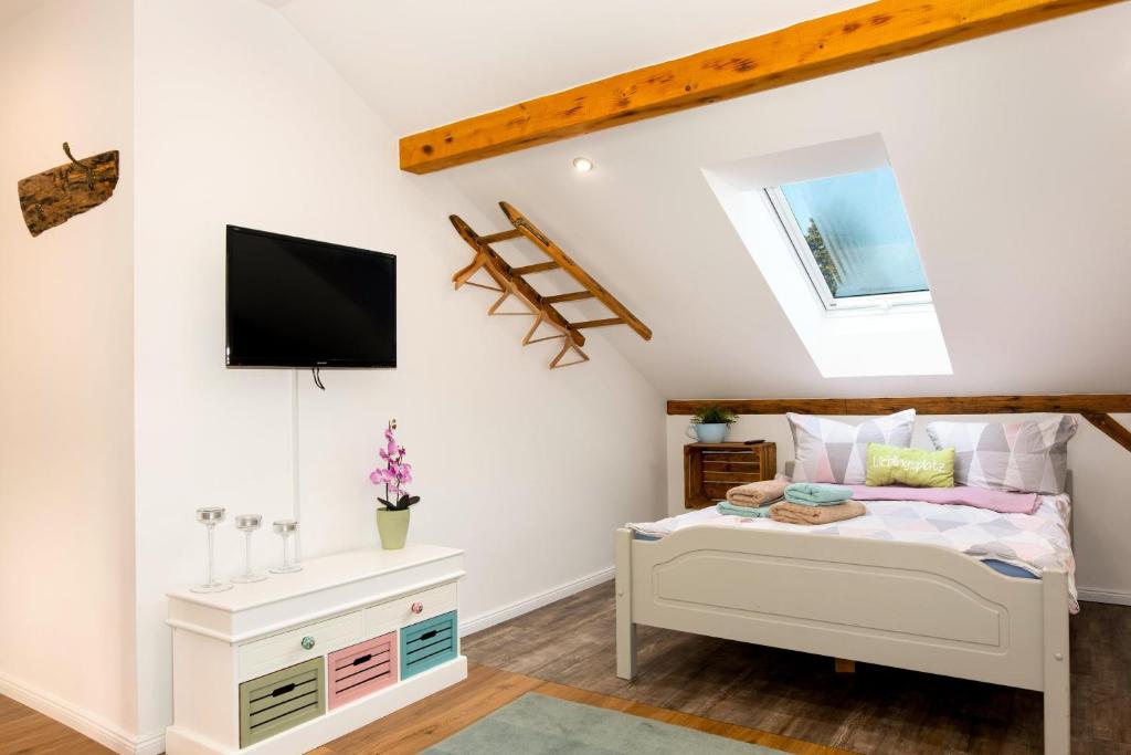 a bedroom with a bed and a tv on a wall at Ferienwohnung Kunterbunt Eckernförde in Eckernförde
