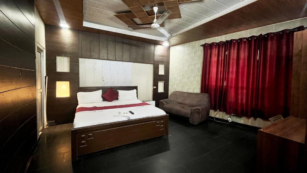 a bedroom with a bed and a red curtain at Hotel New Royal Plaza in Chandīgarh
