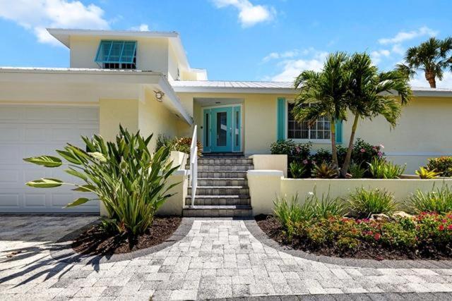 una casa bianca con una porta blu e alcune piante di Beach Daze Sanibel a Sanibel