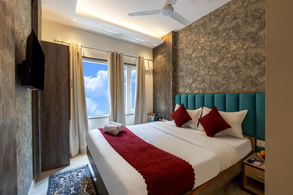 a bedroom with a bed with red pillows and a window at Hotel Stay House Inn 3 Mints walk from New Delhi Railway station,5 Mints from Metro in New Delhi