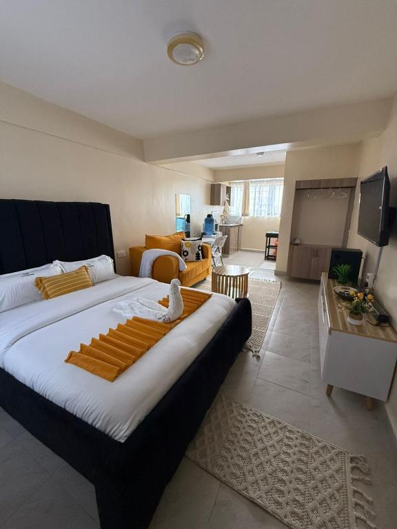 a bedroom with a large bed and a living room at Staycation by Winnie-NAIPOSHA STUDIOS in Naivasha