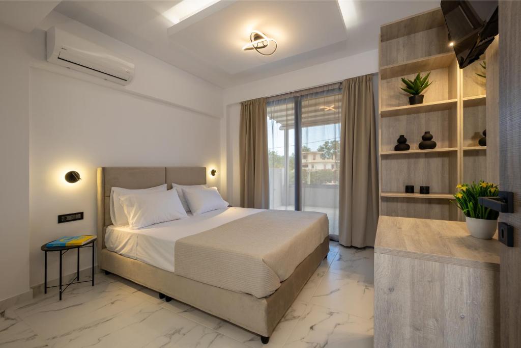 a bedroom with a large bed and a window at Valianos Studios - Luxury Apartment in Alikanas