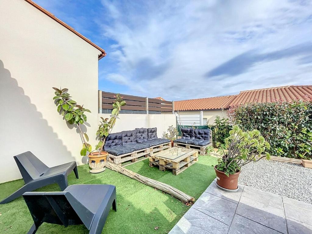 patio con sedie blu e tavolo in legno di Villa 6 couchages avec jardin a Ortaffa