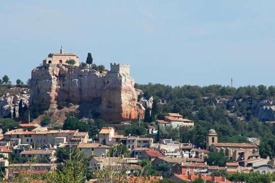 une ville sur une colline avec un château sur une montagne dans l'établissement Le rocher, à Vitrolles