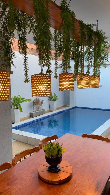 a table with a bowl on top of it next to a pool at Casa villa Gravatá in Gravatá