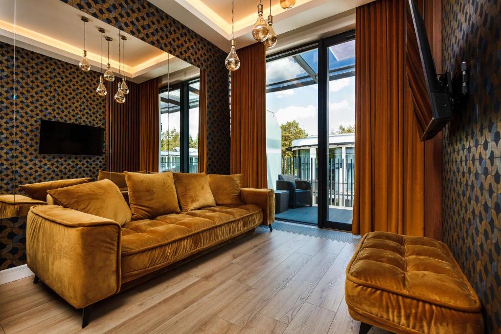 a living room with a brown couch and a large window at Stegna Gold Amber Apartment in Stegna
