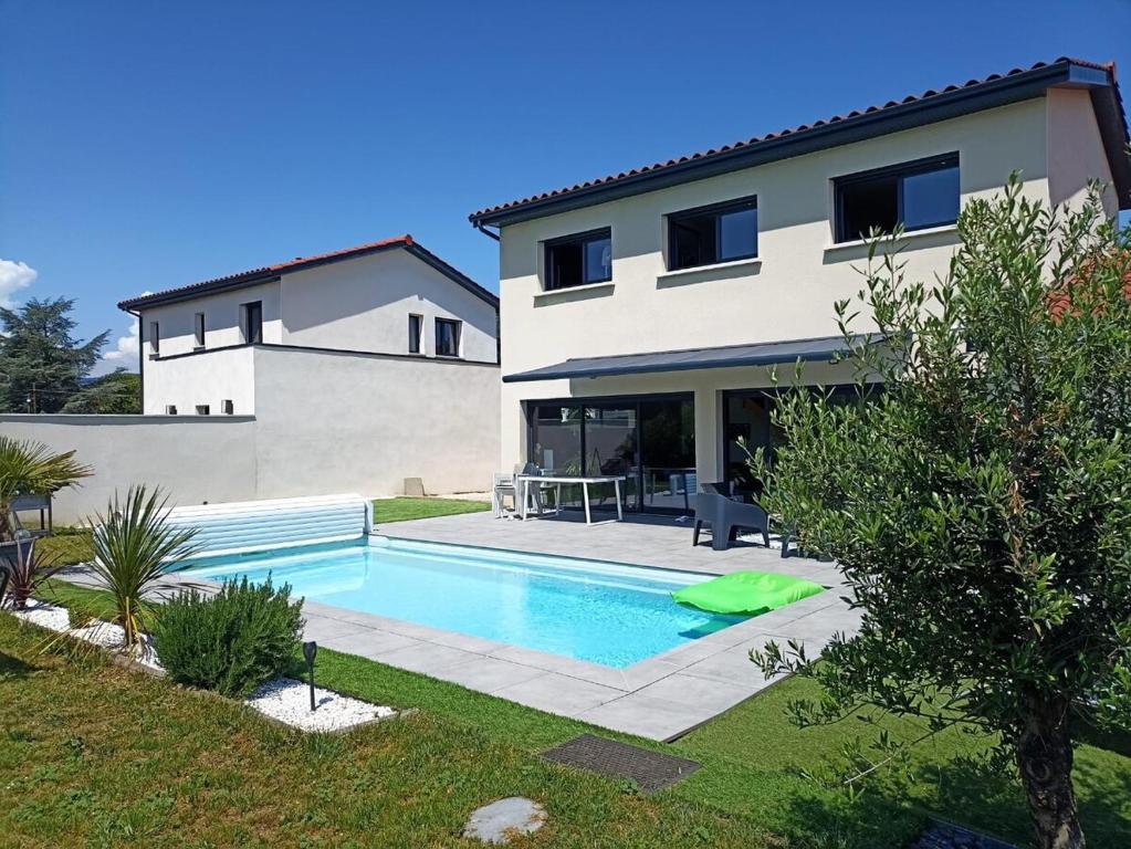 une maison avec une piscine devant une maison dans l'établissement Maison avec piscine, jardin et barbecue, à Craponne
