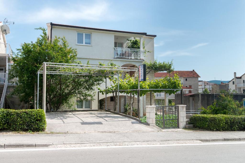 a white house with a gate in front of it at Apartments&Rooms SB in Neum