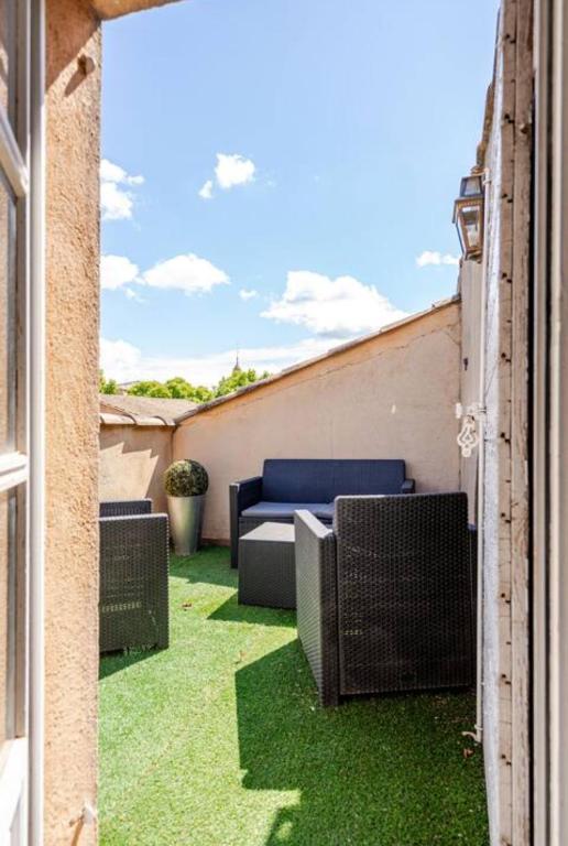 une vue extérieure d'un patio avec de l'herbe verte dans l'établissement Aix-en-Provence : appartement de charme centre ville, à Aix-en-Provence
