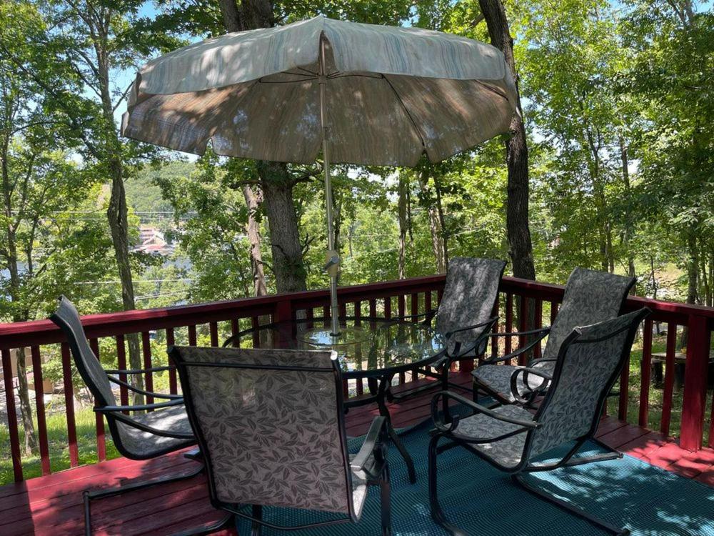 a table and chairs on a deck with an umbrella at Lakeview Retreat at Sunrise Beach in Sunrise Beach
