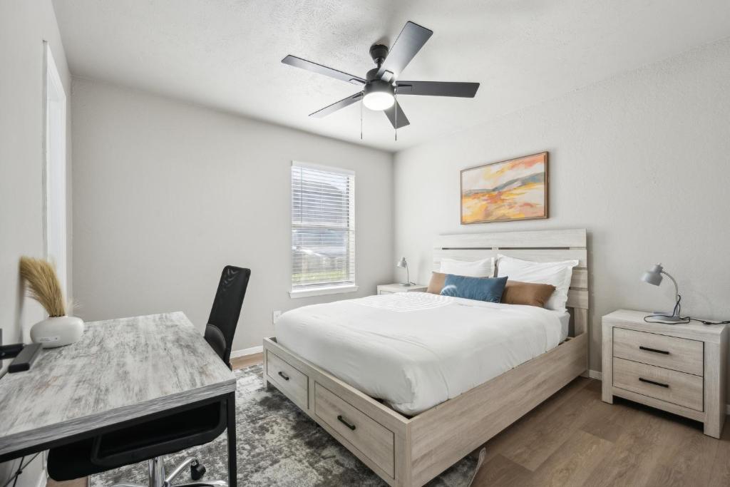 a bedroom with a bed and a desk and a ceiling fan at The Chandler 1111 I Comfy 2 Bed 2 Bath in Grand Prairie
