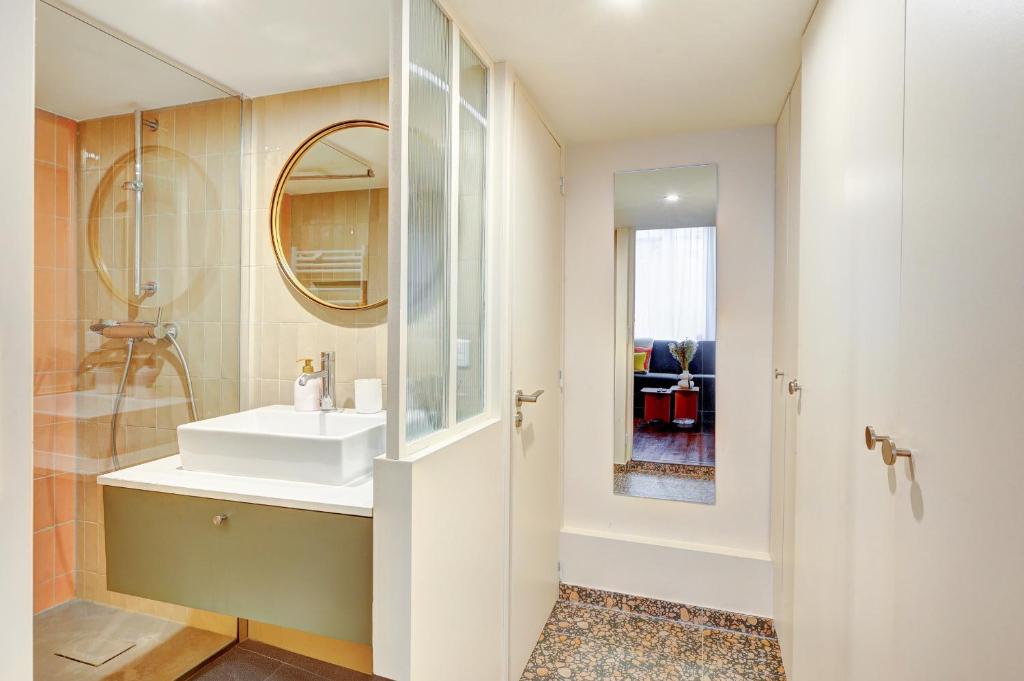 une salle de bain avec un lavabo et un miroir dans l'établissement Coco meulin rouge, à Paris