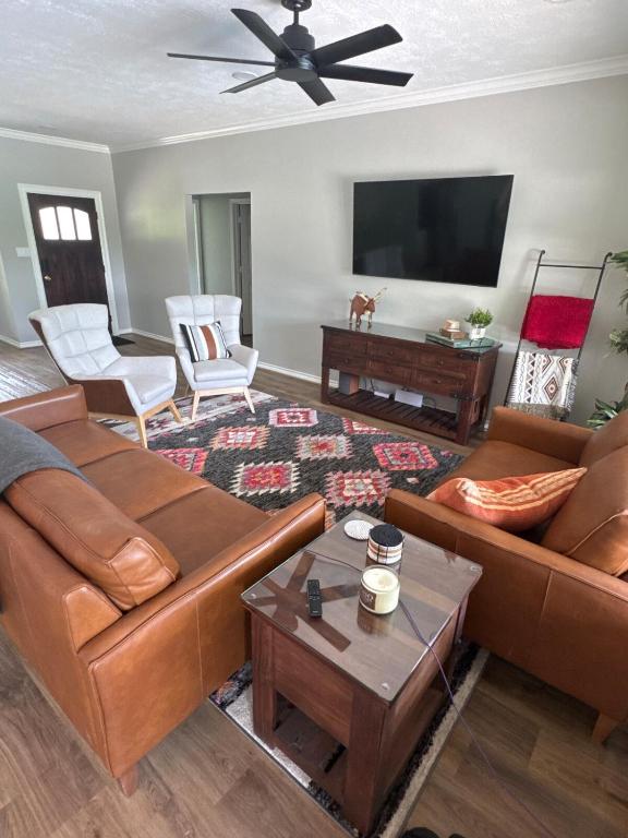 a living room with leather furniture and a flat screen tv at Limestone Hideaway in Jewett