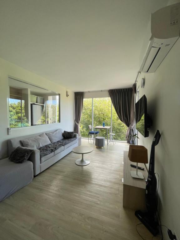 een woonkamer met een bank en een tafel bij Le Grand Bleu in Koh Samui 