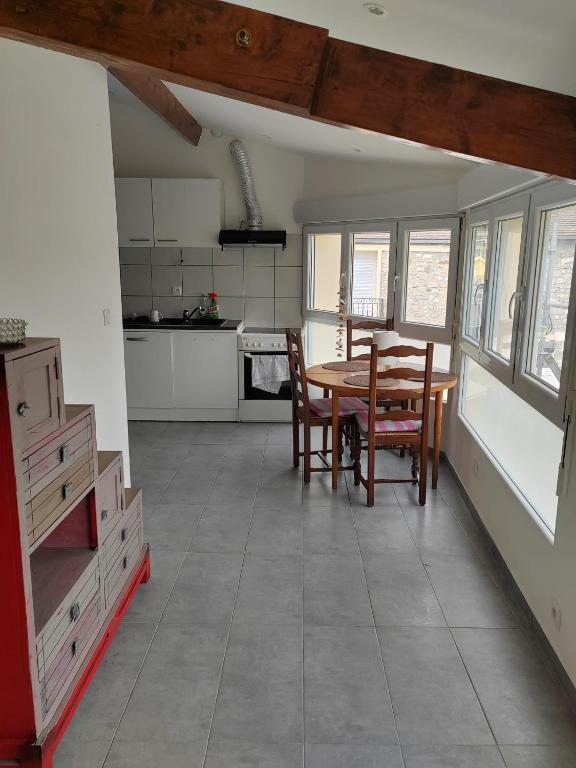 une cuisine avec une table et des chaises dans une pièce dans l'établissement Agréable studio près de cergy, à Ableiges