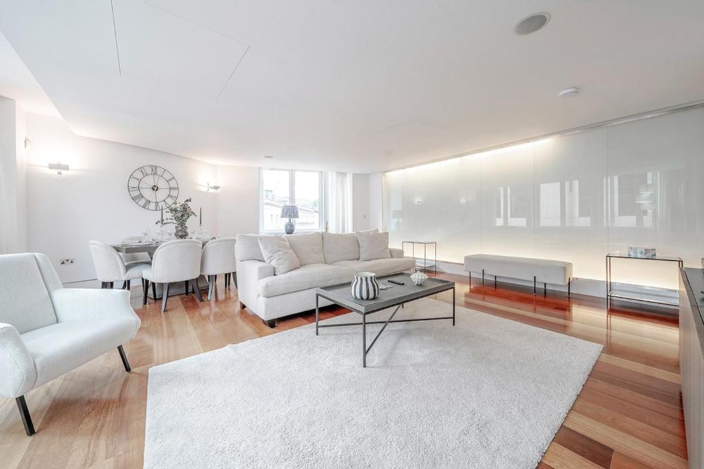 a living room with a white couch and a table at Harrods Platinum Pad in London