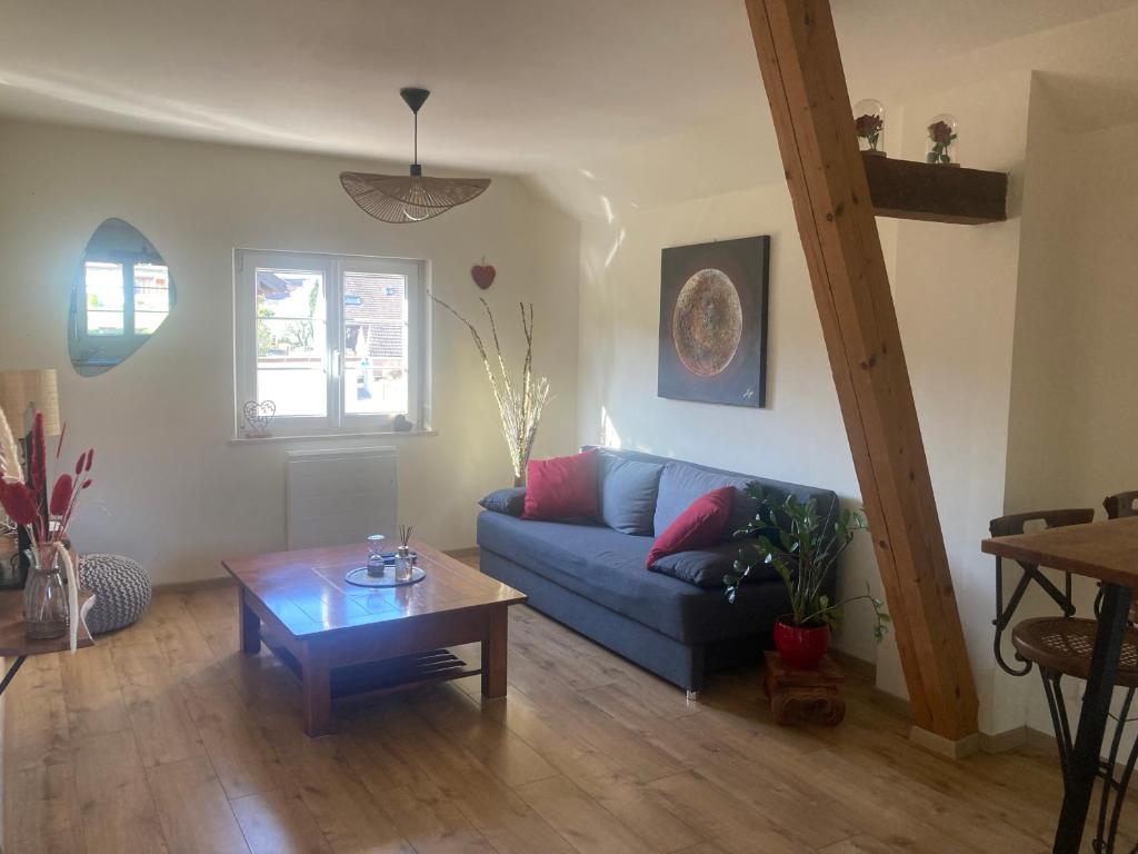 un salon avec un canapé bleu et une table dans l'établissement Le linele, à Handschuheim