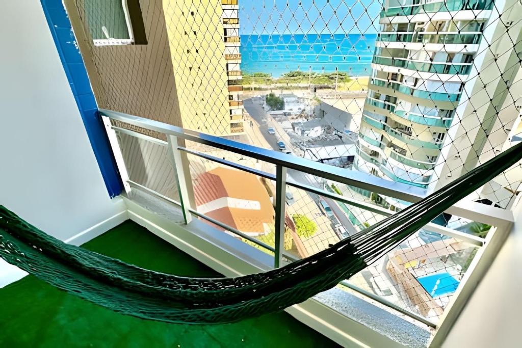 a hammock on a balcony with a view of a city at M901 Vista Mar Ar Cond Garagem in Vila Velha