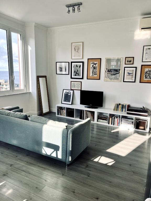 un soggiorno con un divano e una televisione di Quinto between comfort and design a Genova