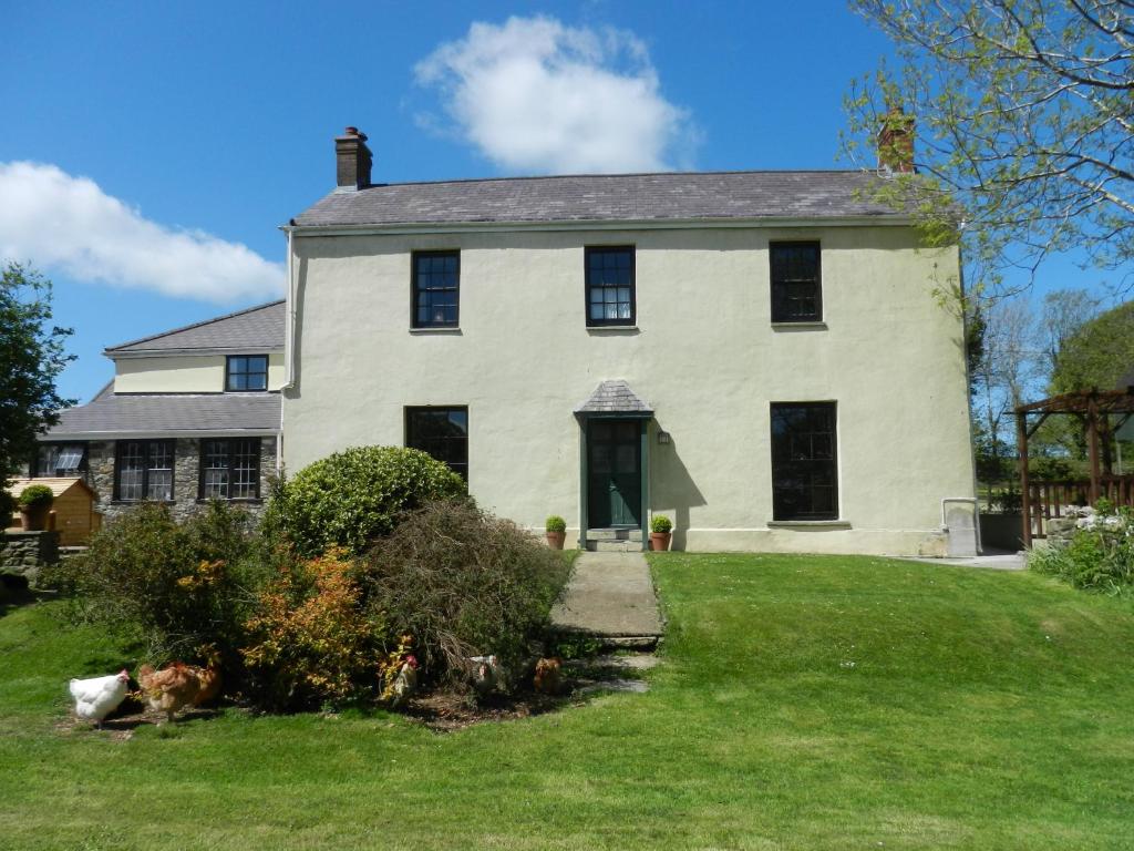 uma grande casa branca com janelas pretas em Cilwen Country House Bed and Breakfast em Abernant