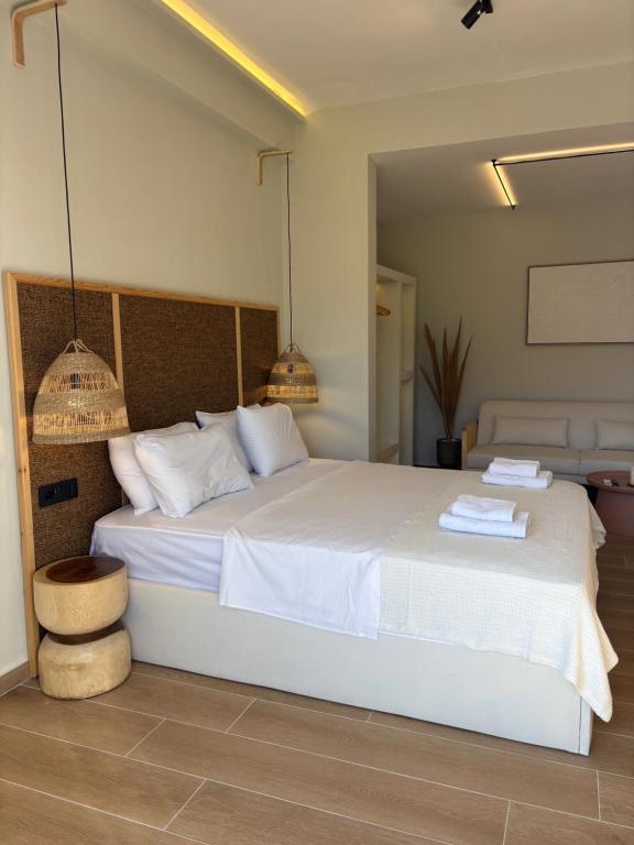 a bedroom with a white bed with two towels on it at Caruso Central Apartments in Lefkada