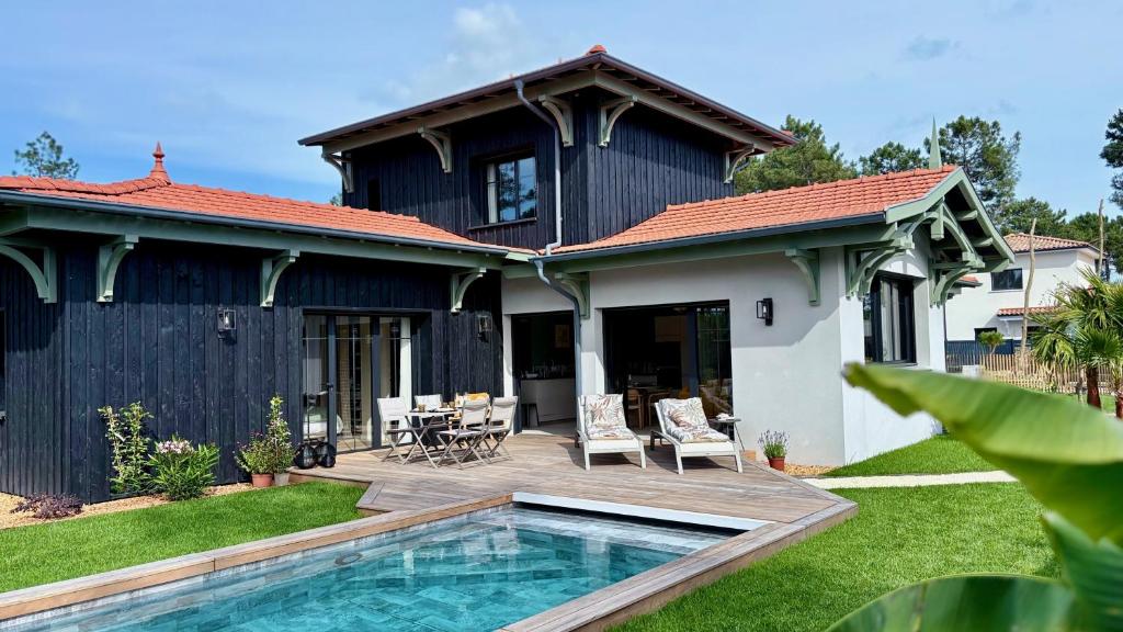 une maison avec une piscine dans la cour dans l'établissement Le Clos des Pins, à Andernos-les-Bains