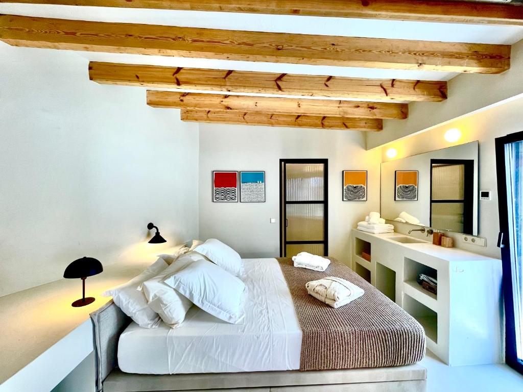 a white bedroom with a bed and a sink at MIMARE Dénia in Denia