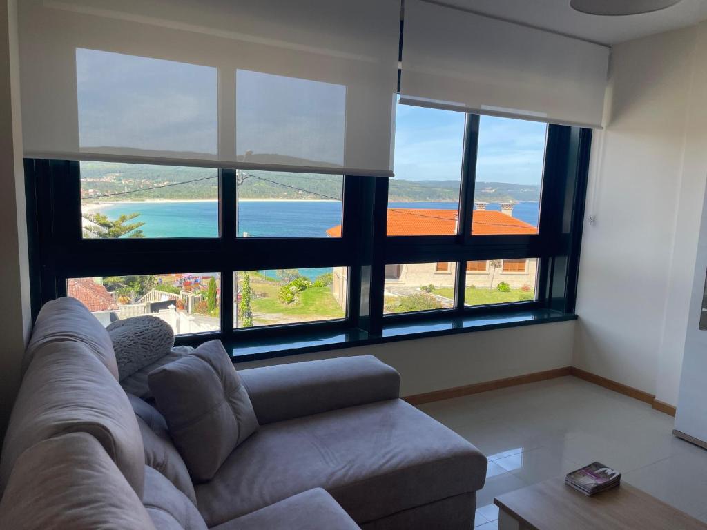 a living room with a couch and a large window at ENV Langosteira in Fisterra