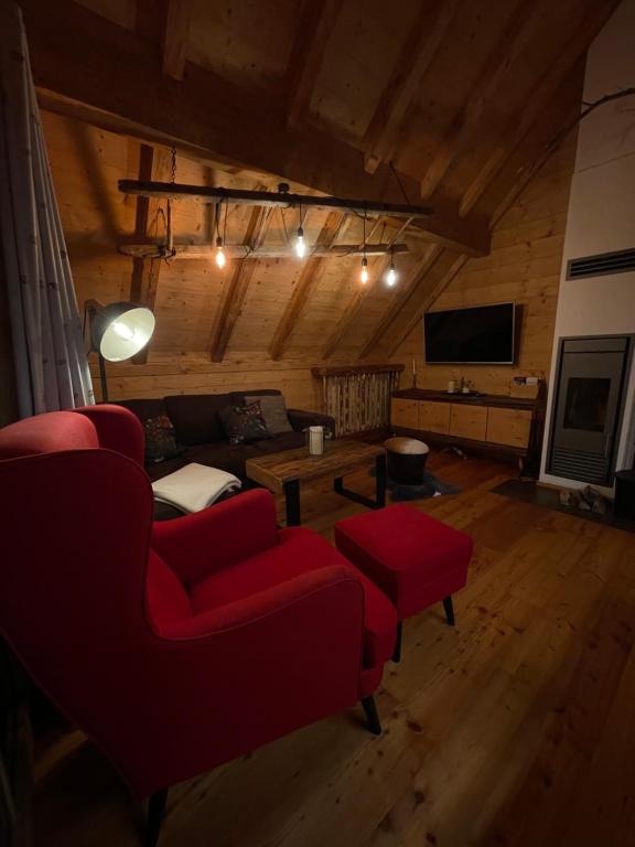 ラッハタールにあるTroadkastn Chalet Lachtalの赤いソファとテーブルのあるリビングルーム